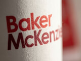 Detaljbild av digitaltryckt Baker McKenzie-logotyp på Pappersmugg dubbelvägg 36 cl i vit med brunt tryck